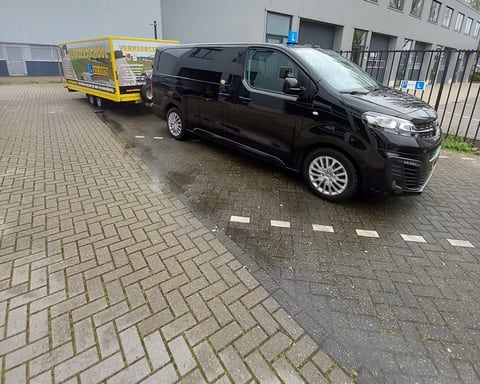 Onze Opel Vivaro met de lesaanhanger voor het kantoor