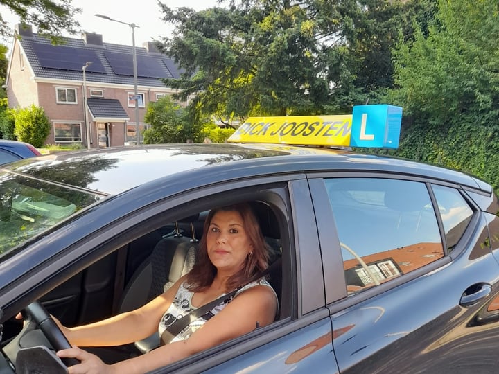 Een leerling achter het stuur van onze lesauto met daklicht