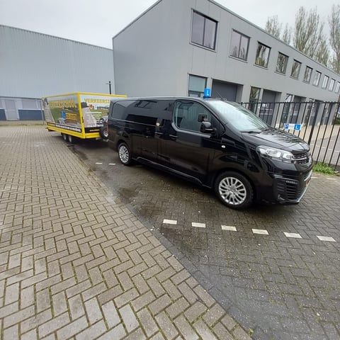 Onze Opel Vivaro met de lesaanhanger voor het kantoor