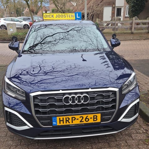 Onze blauwe Audi Q2-lesauto van voren