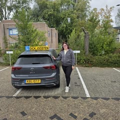 Ashley bij de VW Golf-lesauto na haar examen