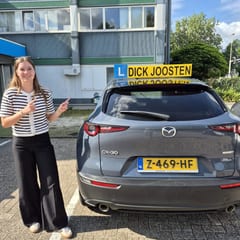 Birke bij de Mazda-lesauto na haar examen