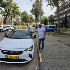 Mogos bij de witte Opel Corsa na zijn examen