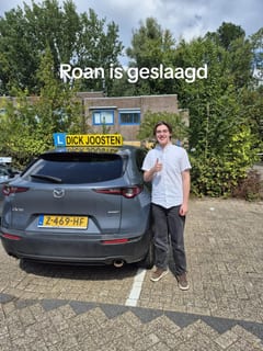 Roan bij de Mazda-lesauto na zijn examen