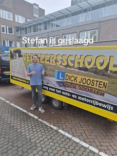 Stefan bij de lesauto na zijn examen