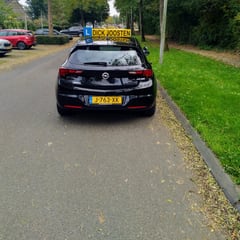 Onze Opel Astra-lesauto onderweg, van achteren