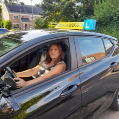 Een leerling achter het stuur van onze lesauto met daklicht